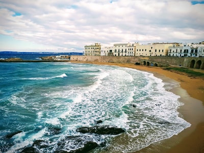 During the day under the white clouds white concrete building of the sea
